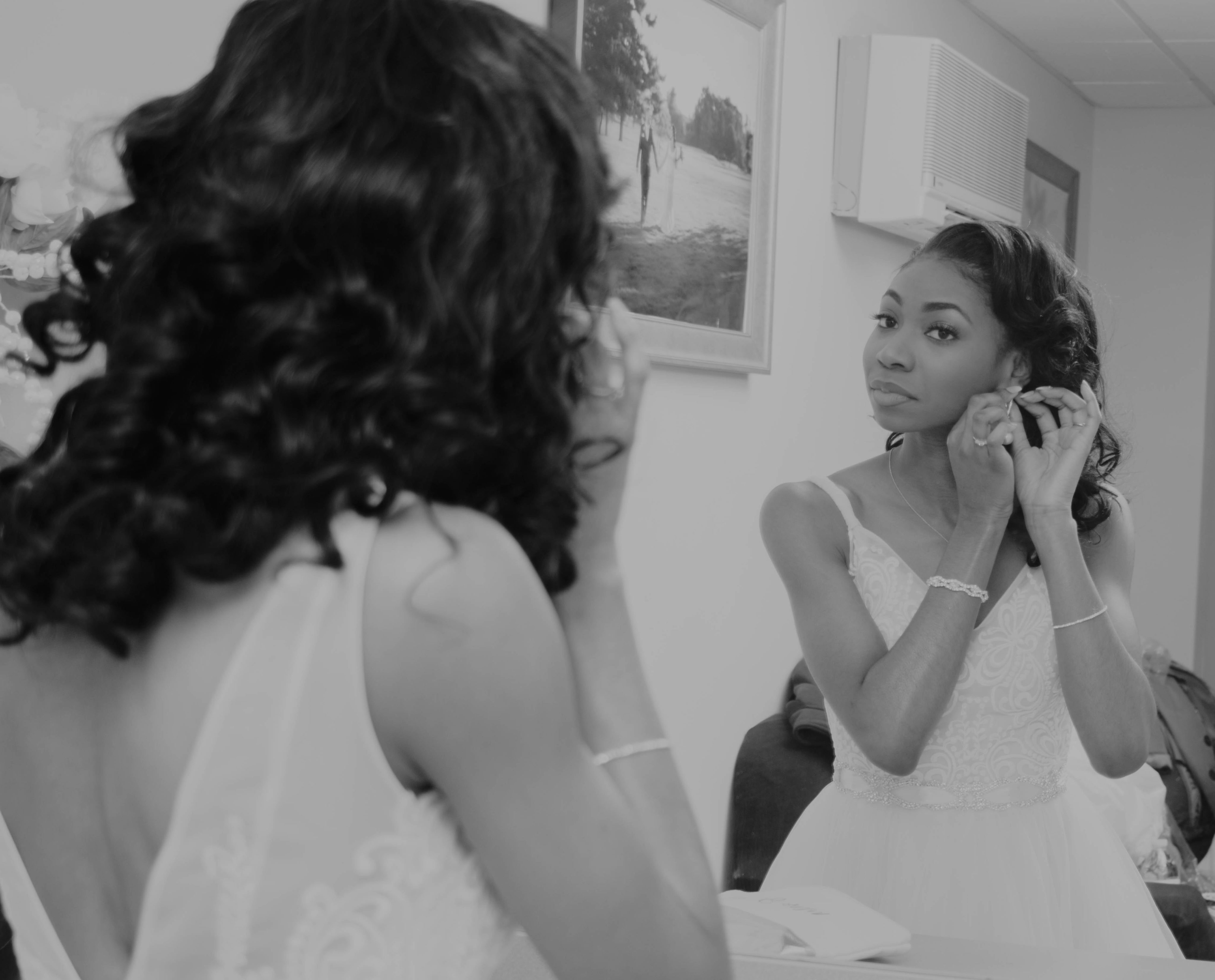 Bride putting on final touches of jewelry