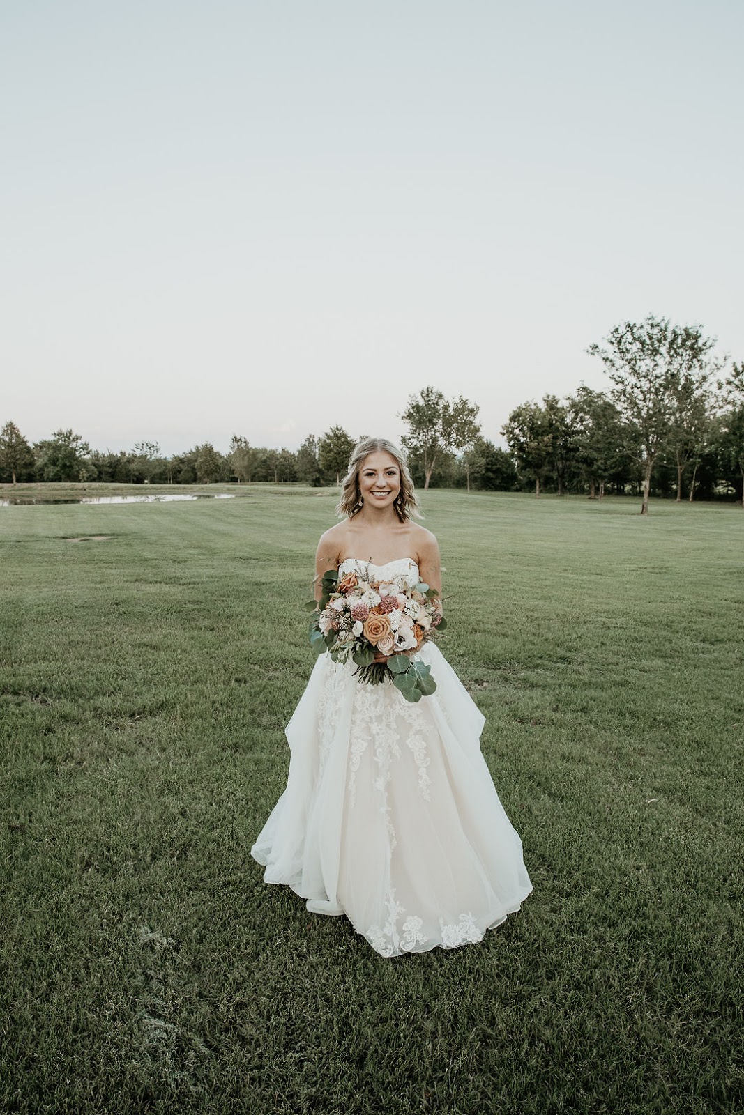 Solo image of bride in dress holding bouquet