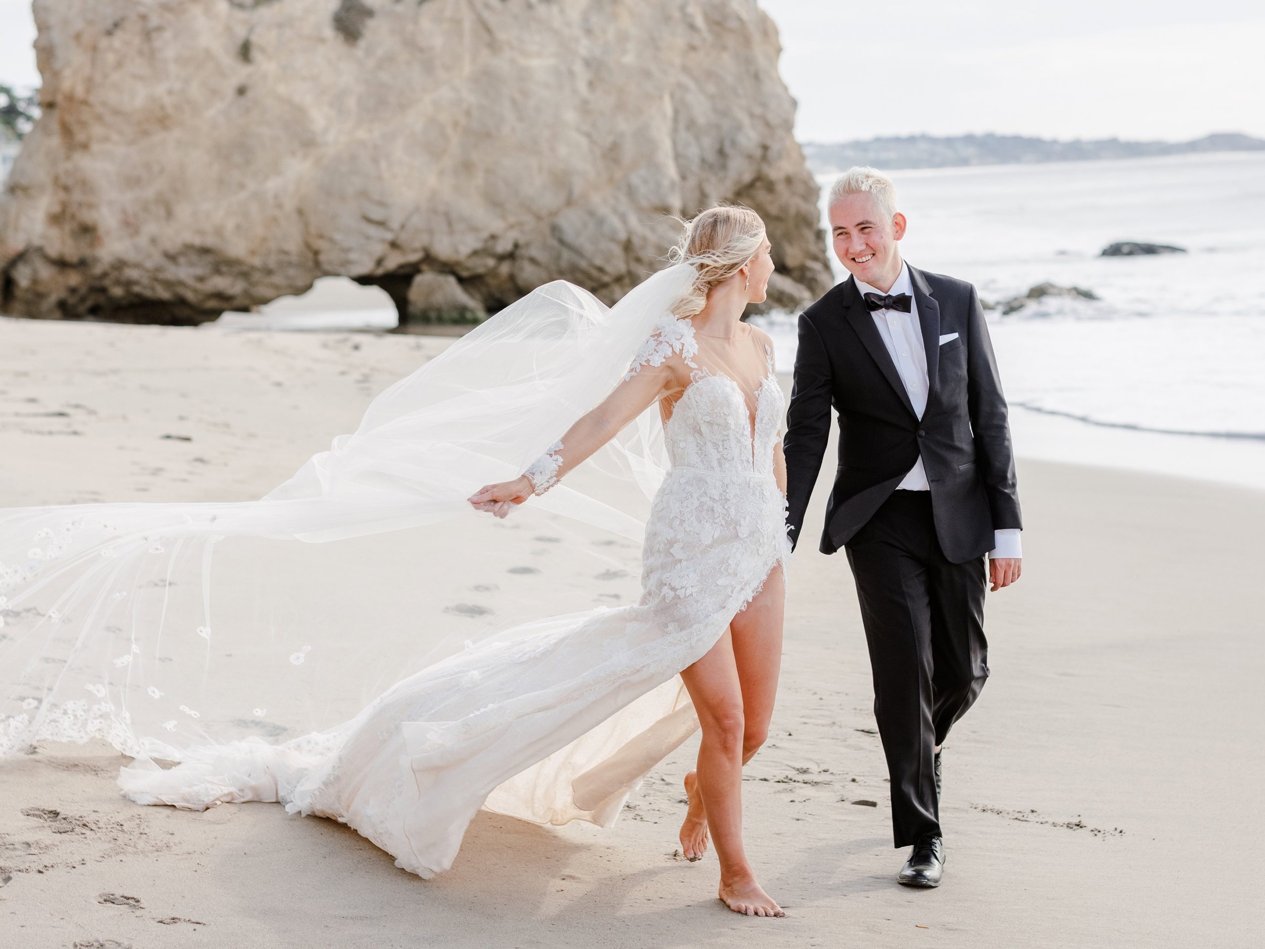 Madison and Sonny holding hands on  beach walk