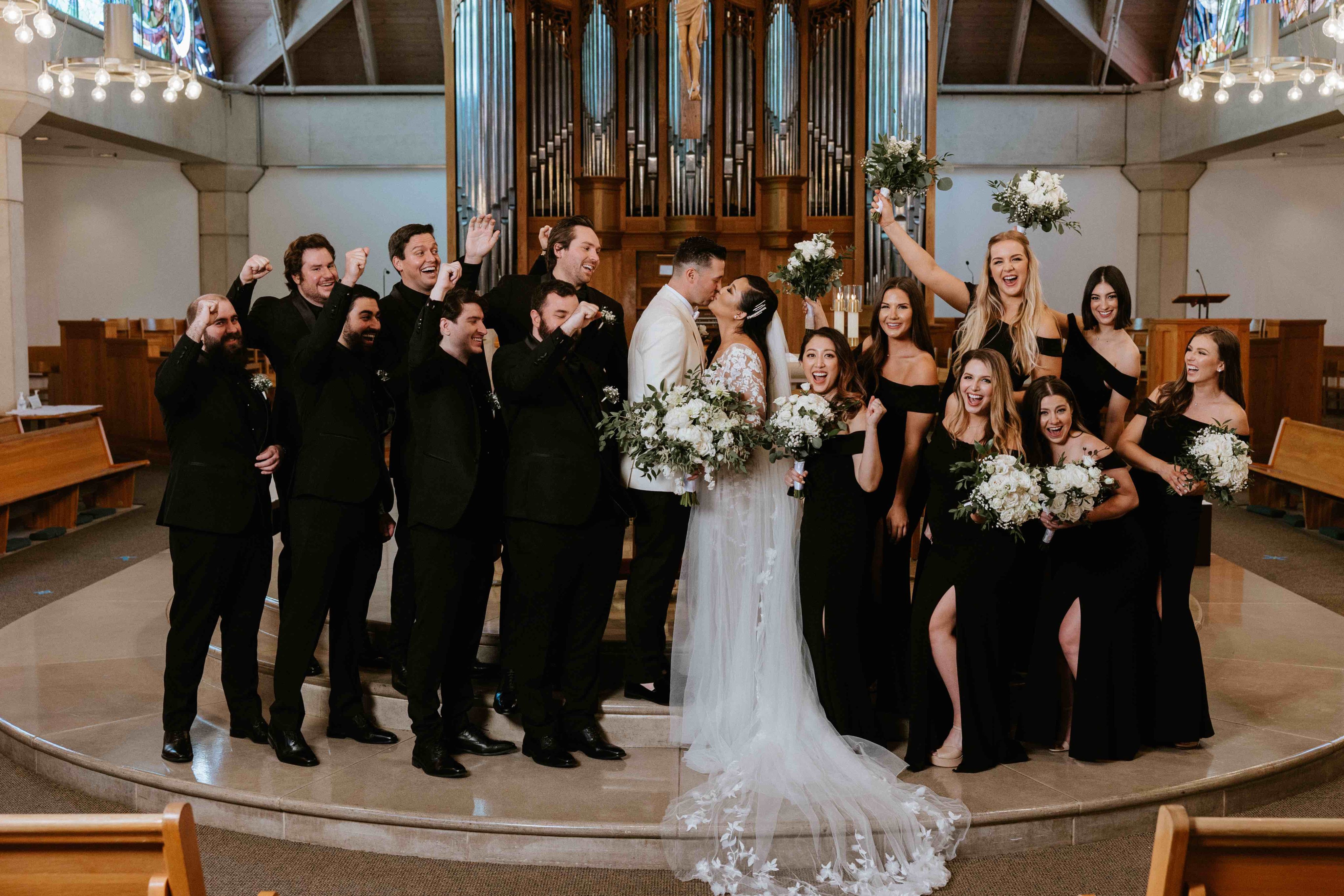 Bride and groom with entire wedding party at altar