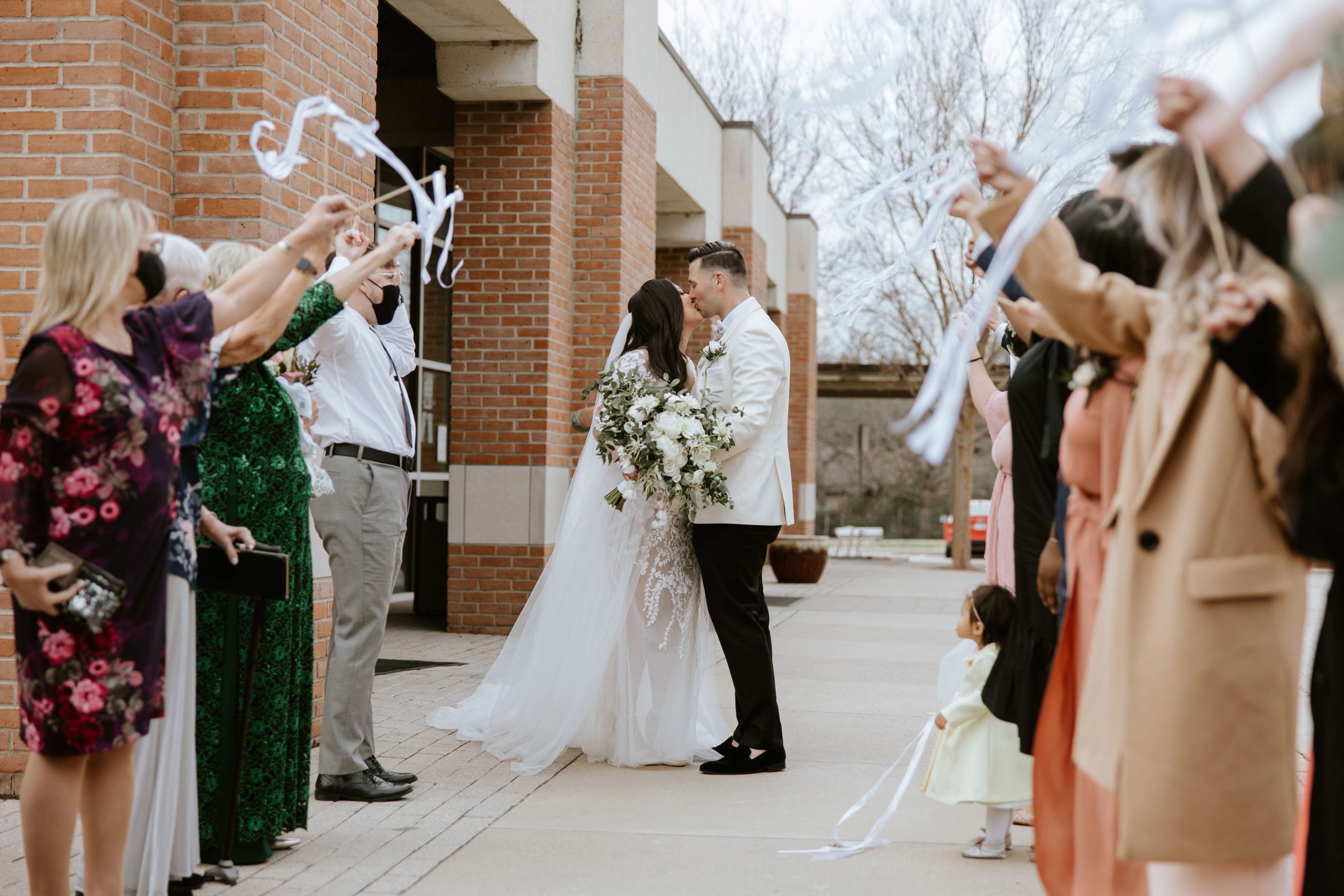 Bride and groom leaving church and kissing
