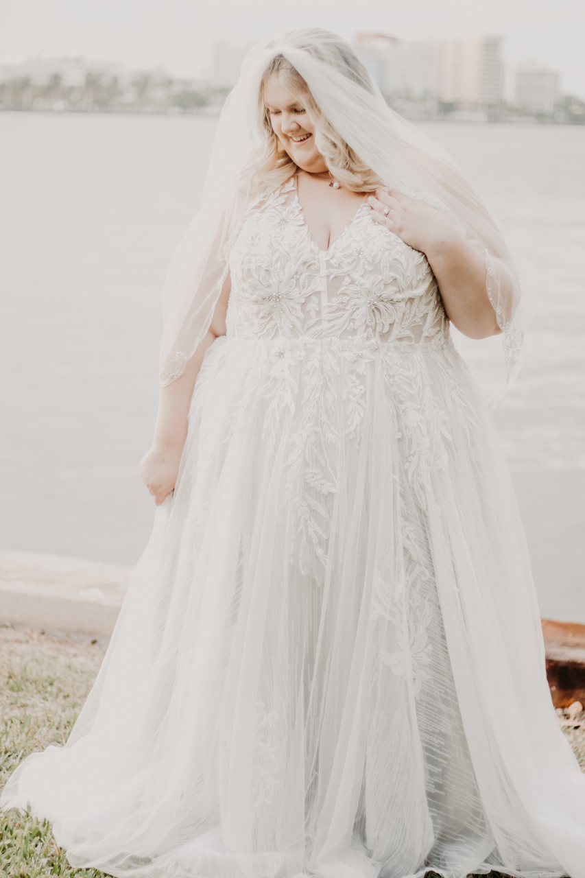 Bride standing wearing a a-line halter neckline wedding dress