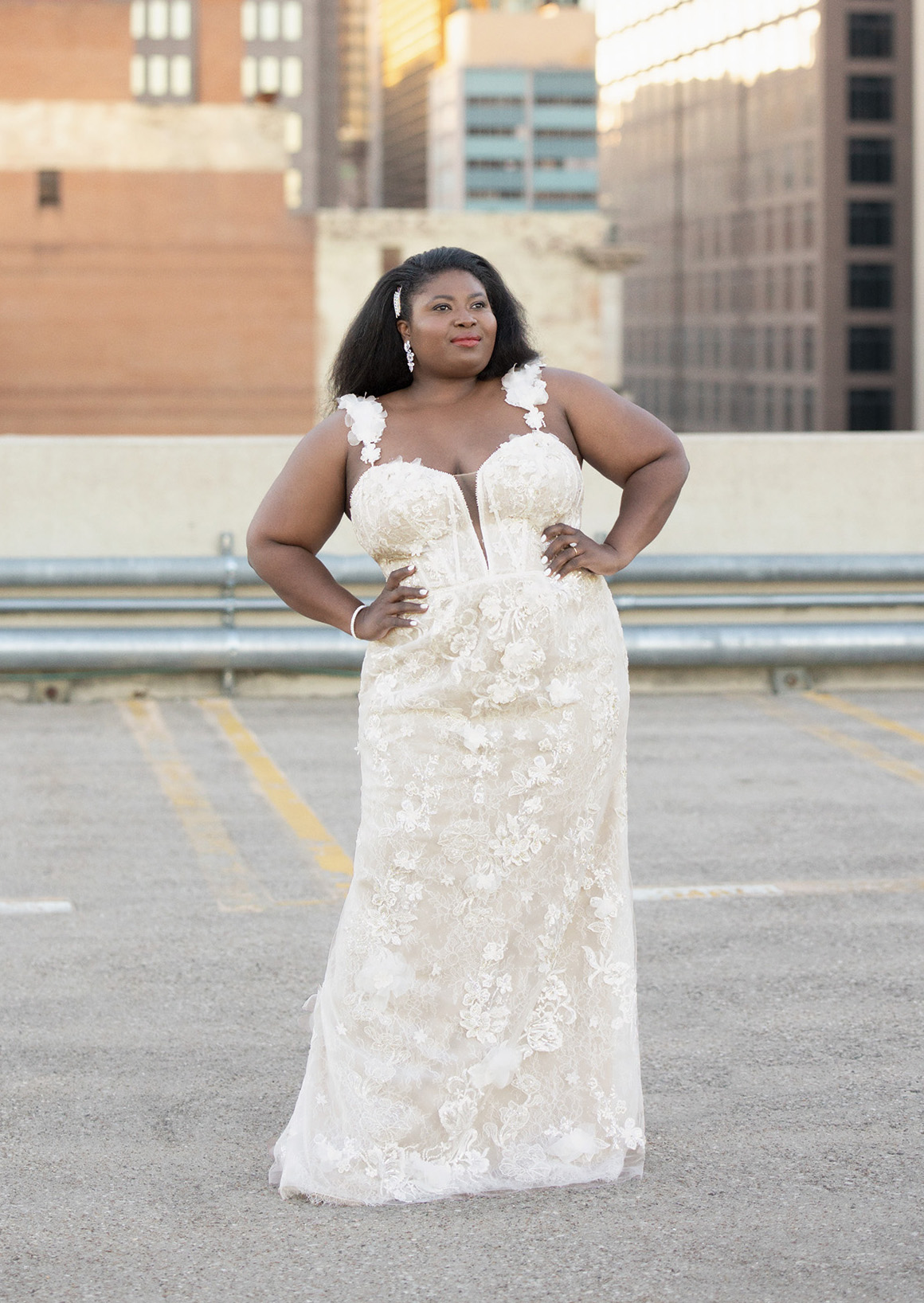 bride standing wearing a sheath style wedding dress with 3D floral appliques