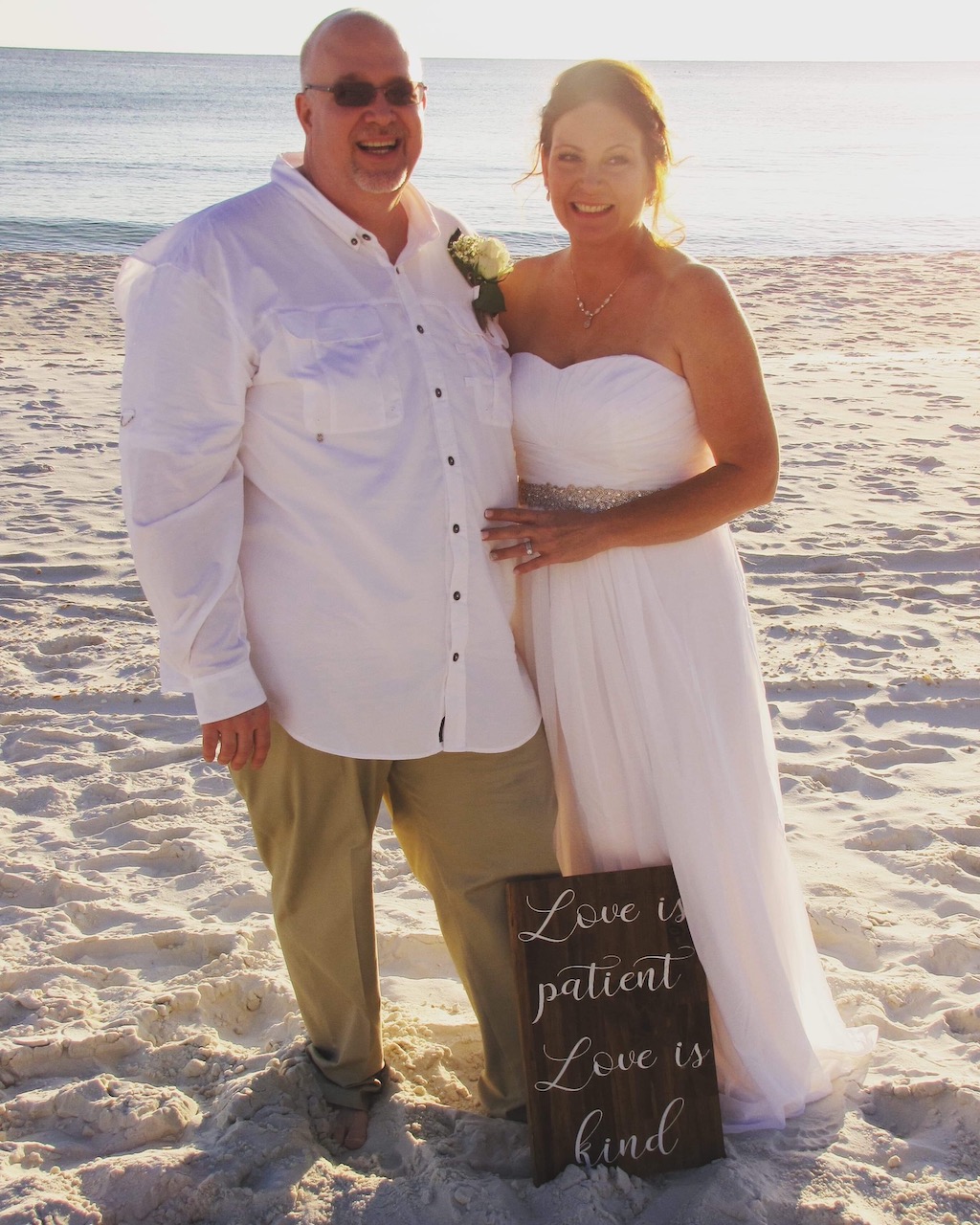 bride and groom standing next to each other on the beach 