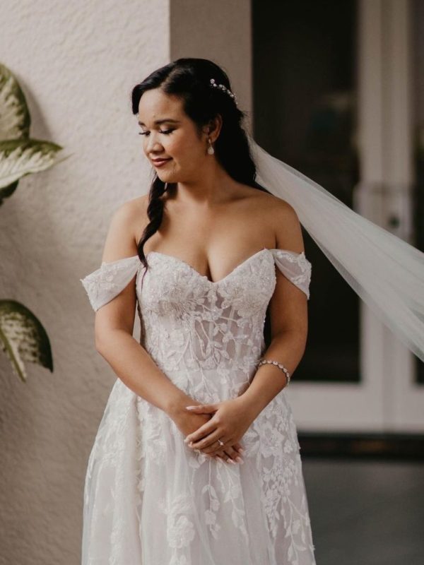 Girl in an off the shoulder wedding dress style.