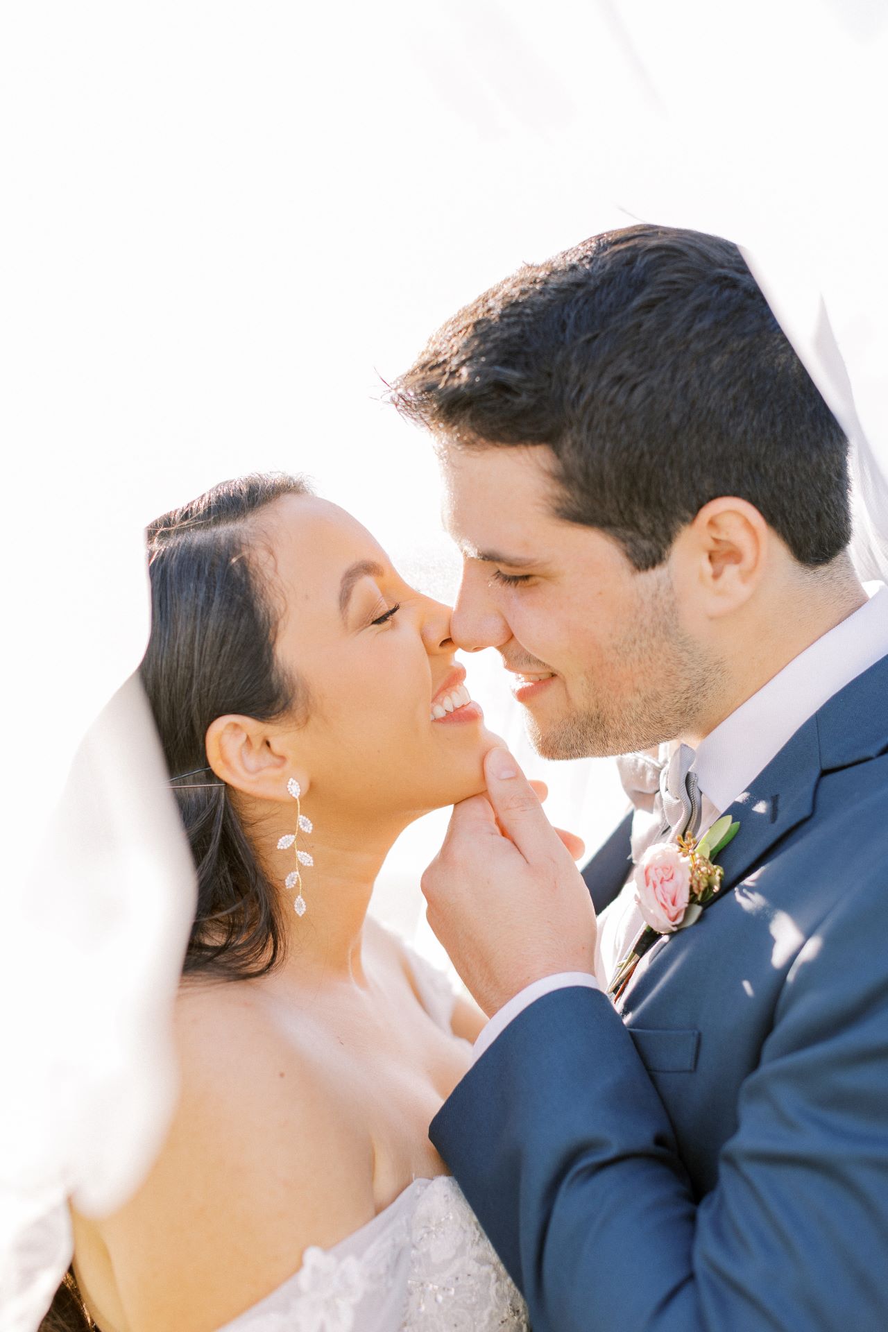 bride and groom embrace in romantic lighting 