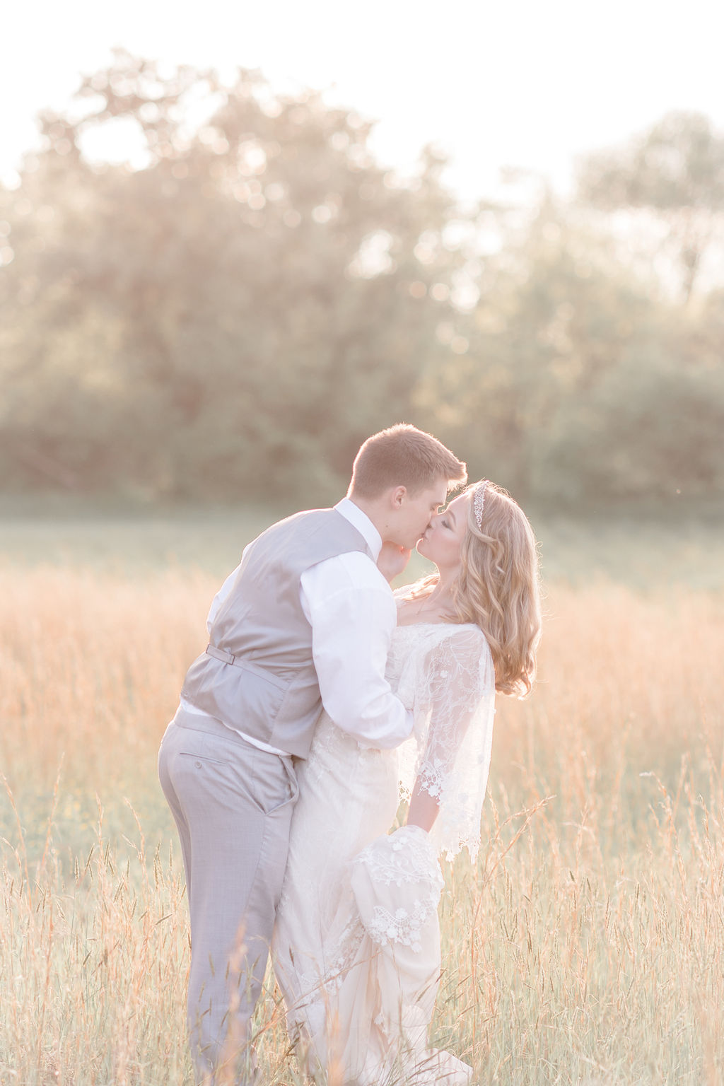 bride and groom kissing at golden hour at dreamy springtime wedding
