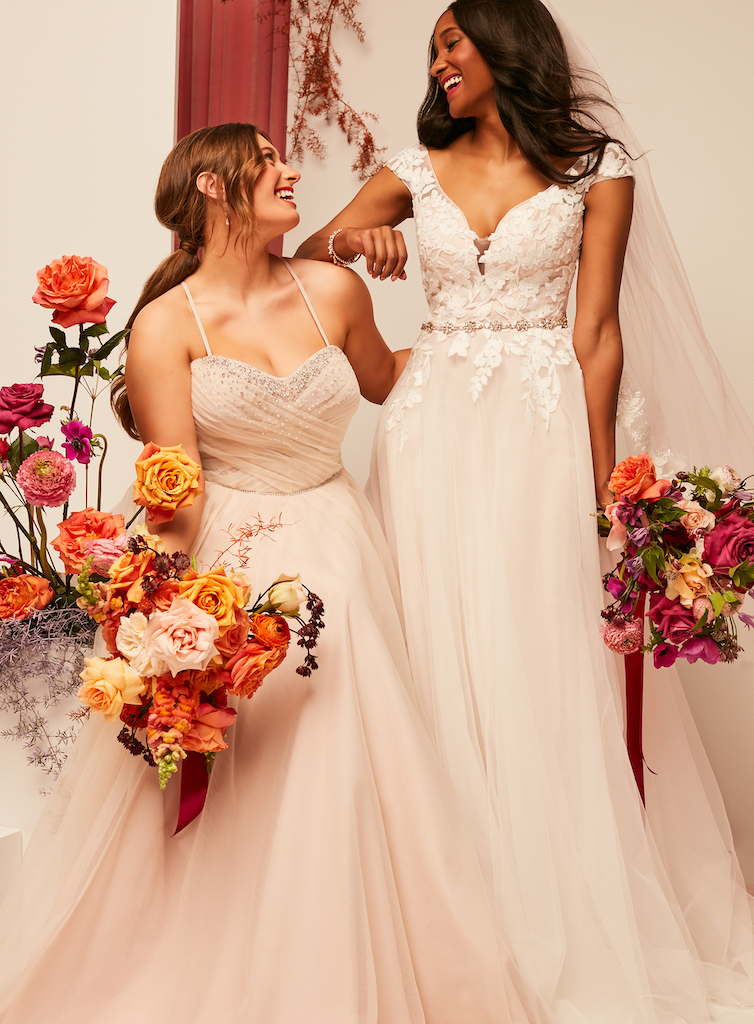 wo brides smiling and laughing at each other in 2021 fall wedding dresses