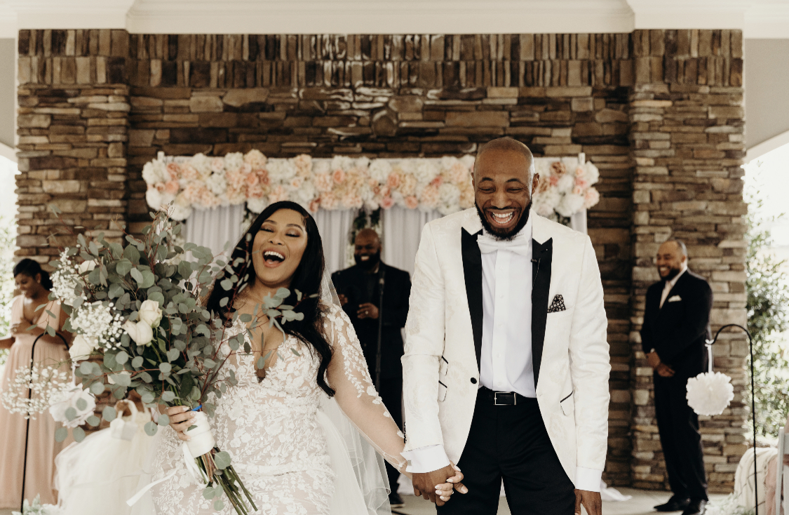 bride and groom walking down the aisle smiling 