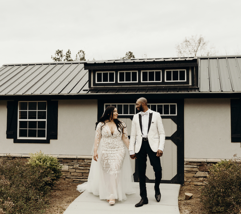 bride and groom walking hand in hand at sexy bohemian wedding