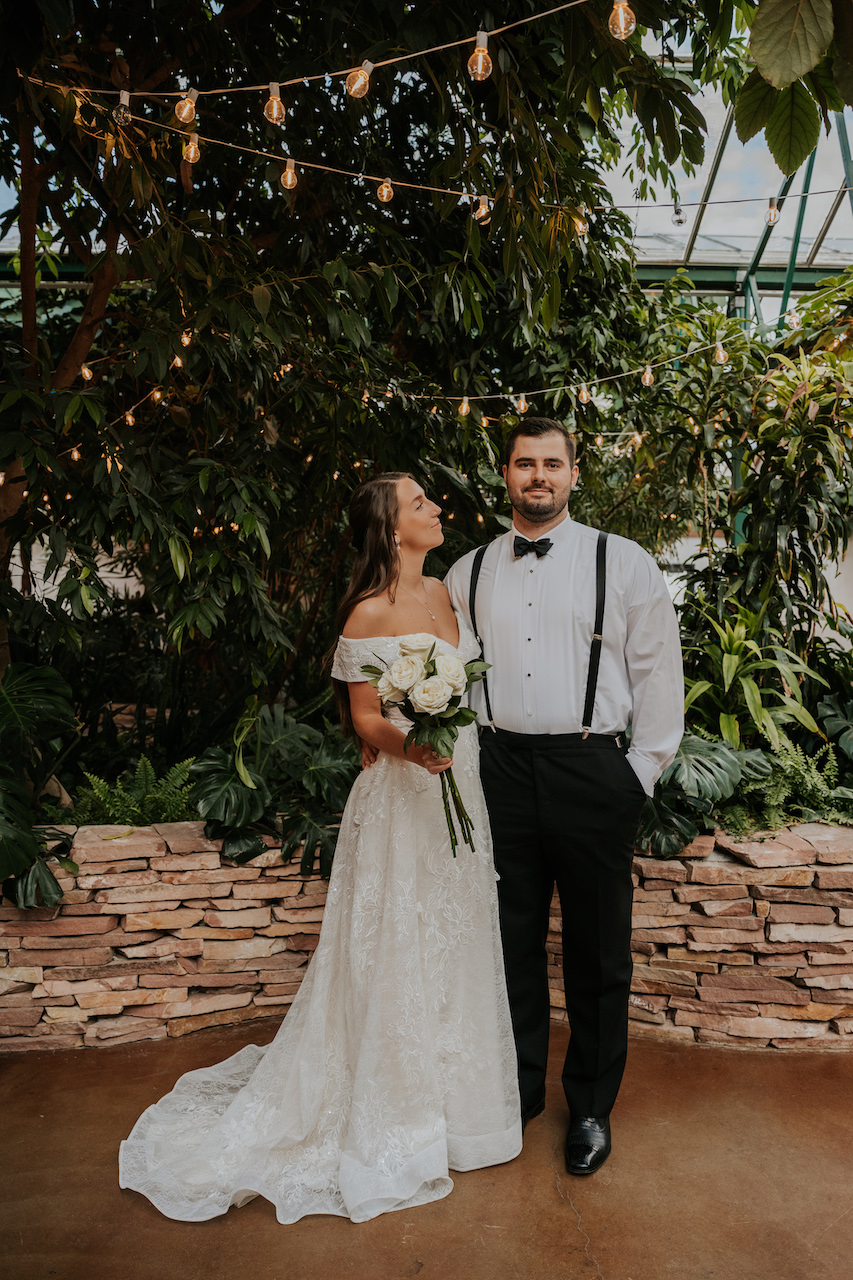 bride and groom standing together at simple and elegant greenhouse wedding