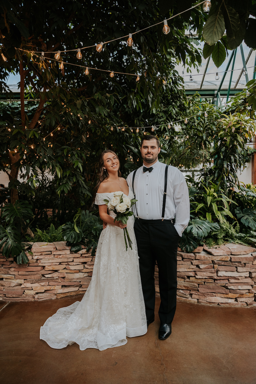 bride and groom standing together at simple and elegant greenhouse wedding