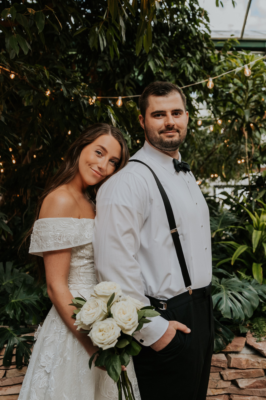 bride and groom posing together at simple and elegant greenhouse wedding