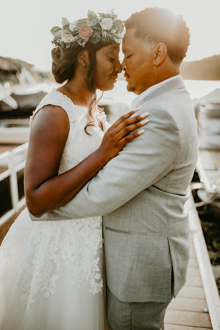 bride and groom embracing at rustic outdoor wedding