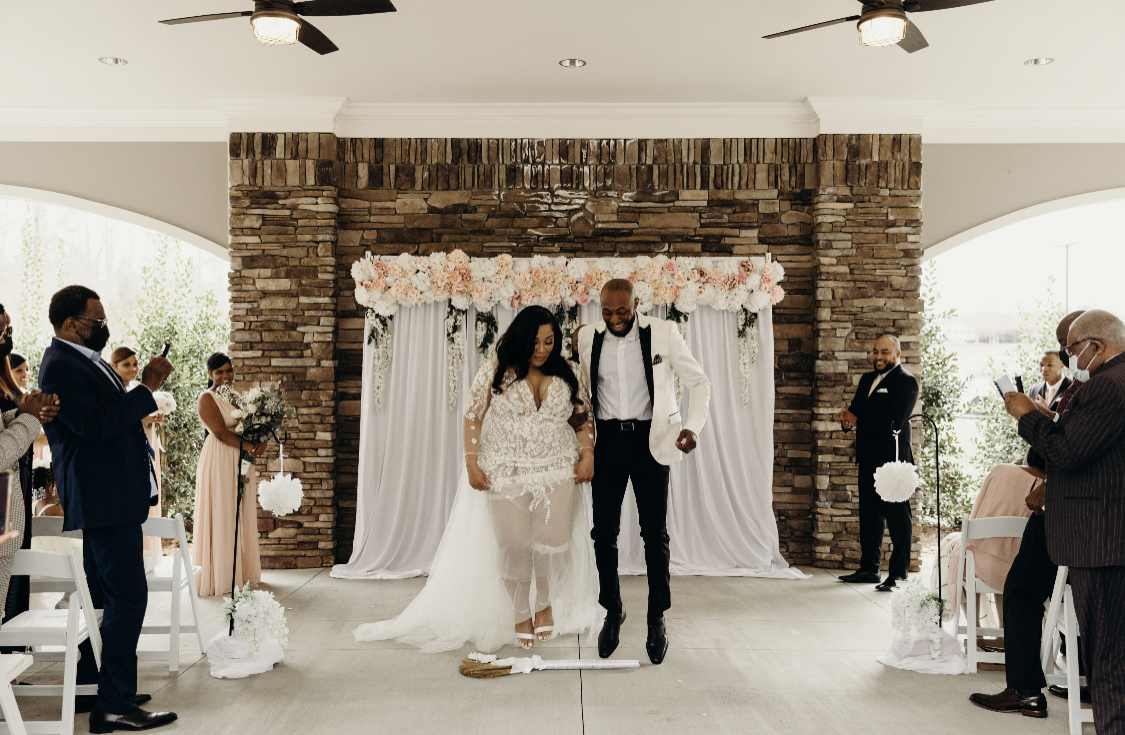 bride and groom jumping the broom