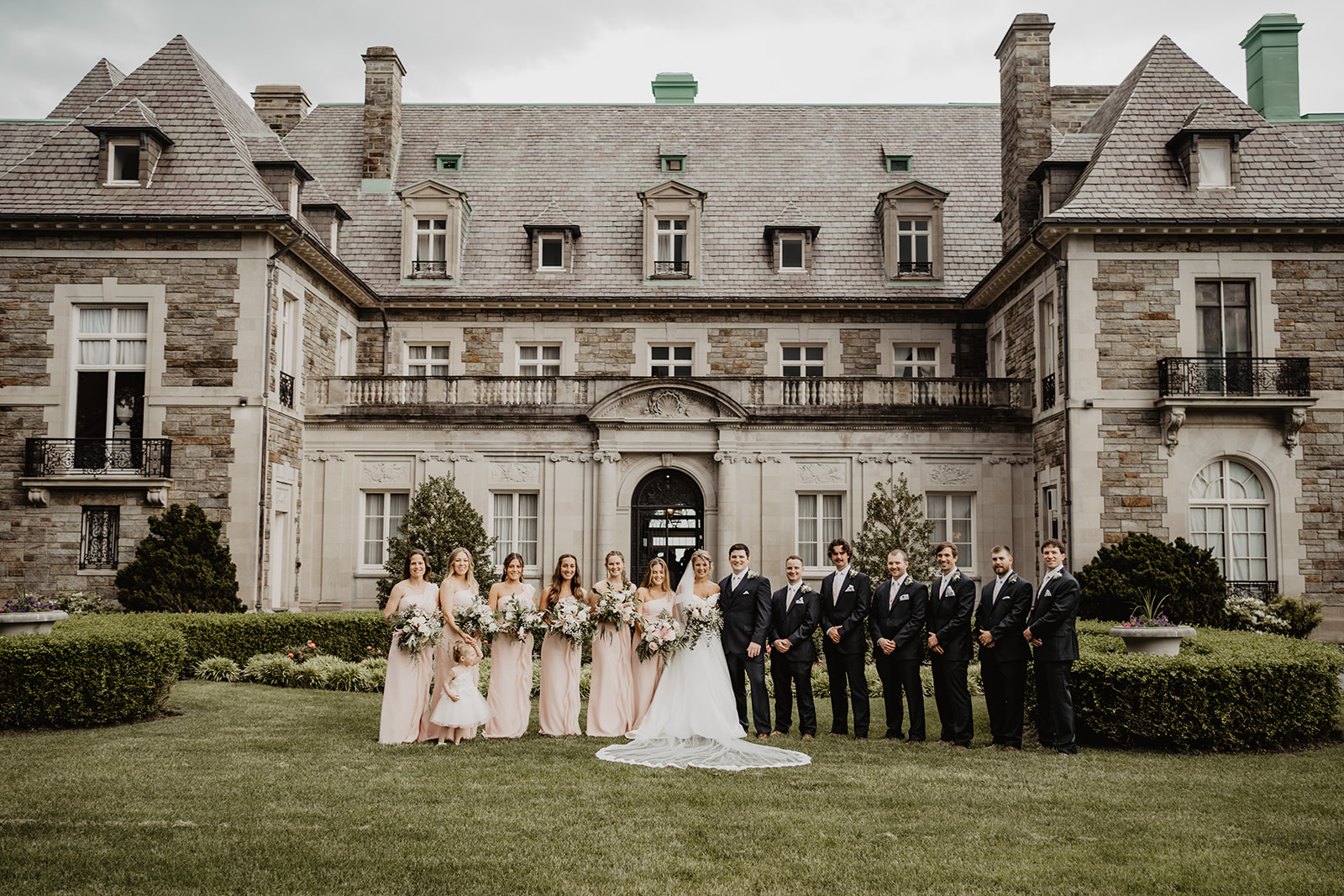 full bridal party in front of mansion 