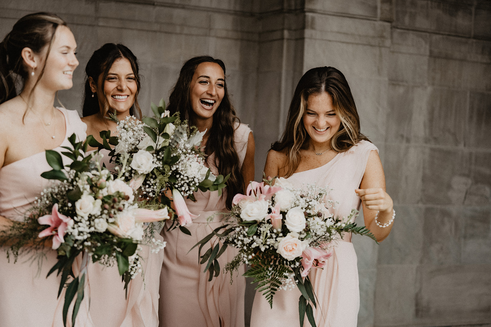 bridesmaids laughing in light pink dresses
