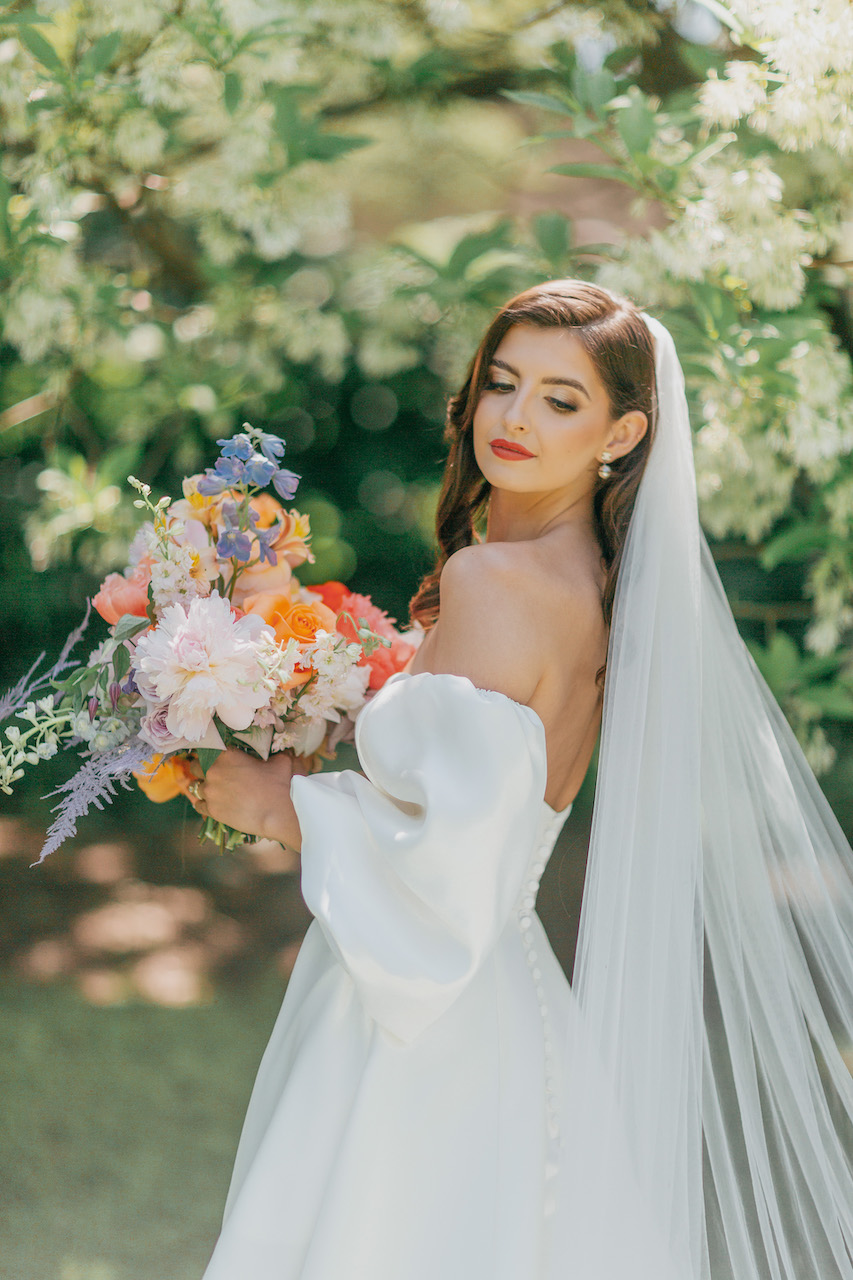 bride in wedding dress with bright colored florals