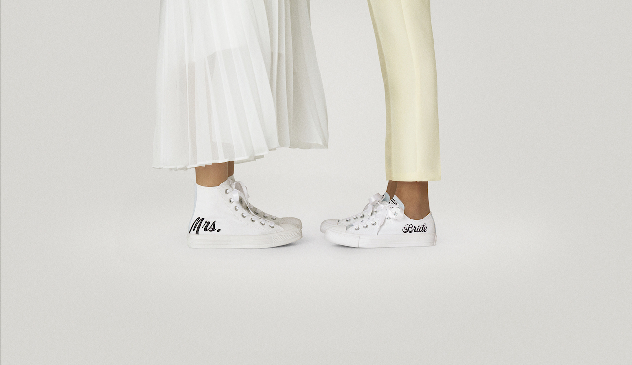 two brides wearing custom wedding sneakers 