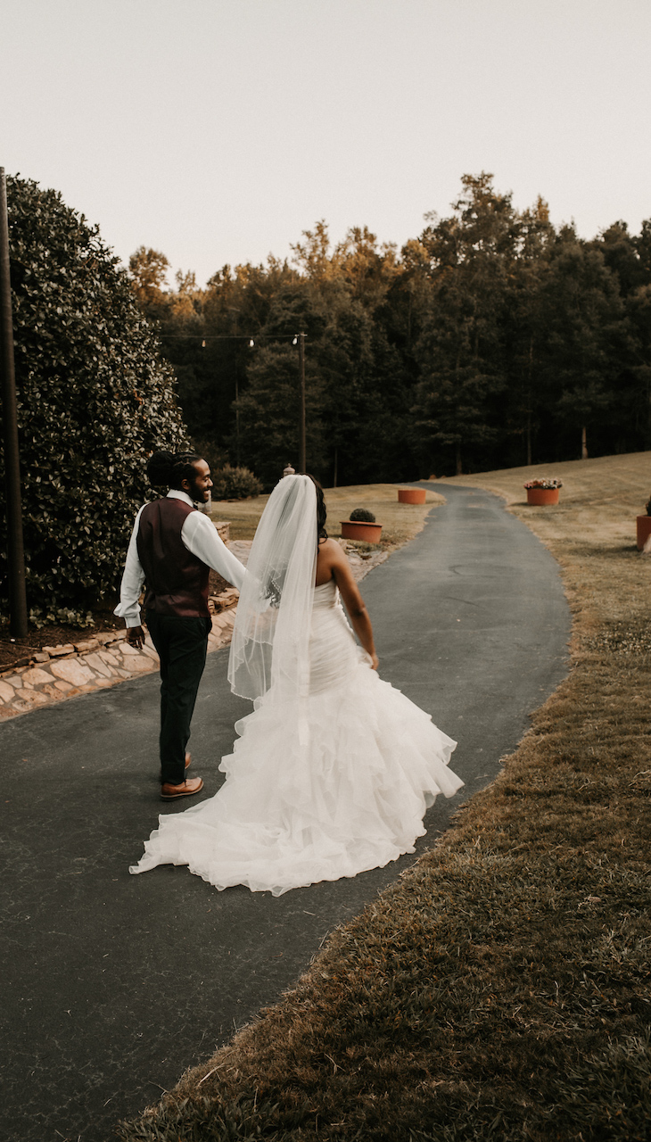 bride and groom walking hand in hand at their simple and elegant fall wedding