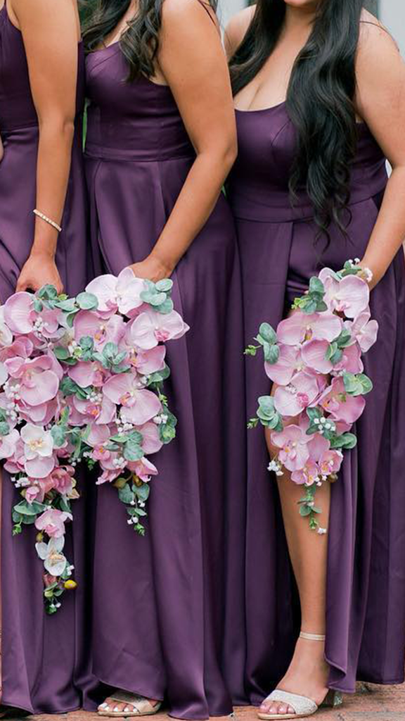 bridesmaids wearing plum-colored dresses and holding pink flowers