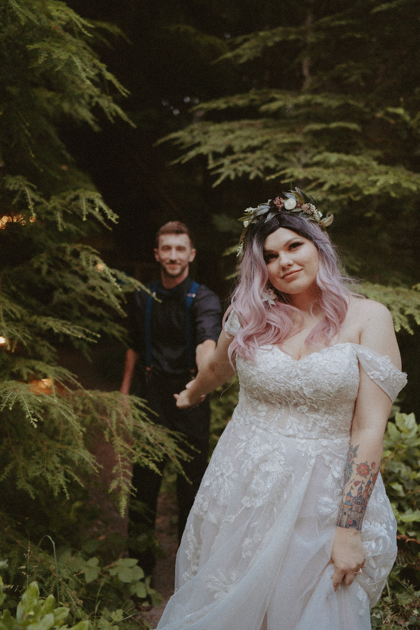 bride and groom walking out of forest