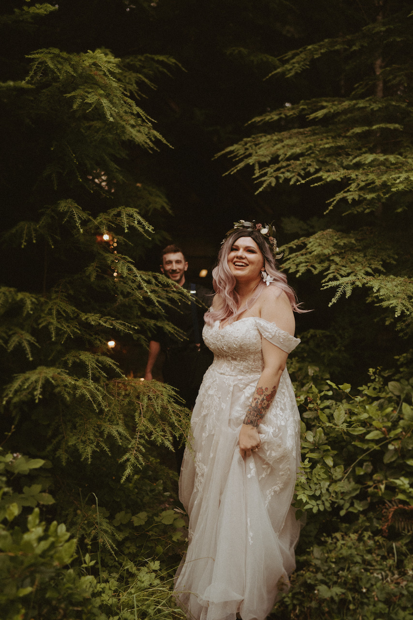 bride and groom walking through forest