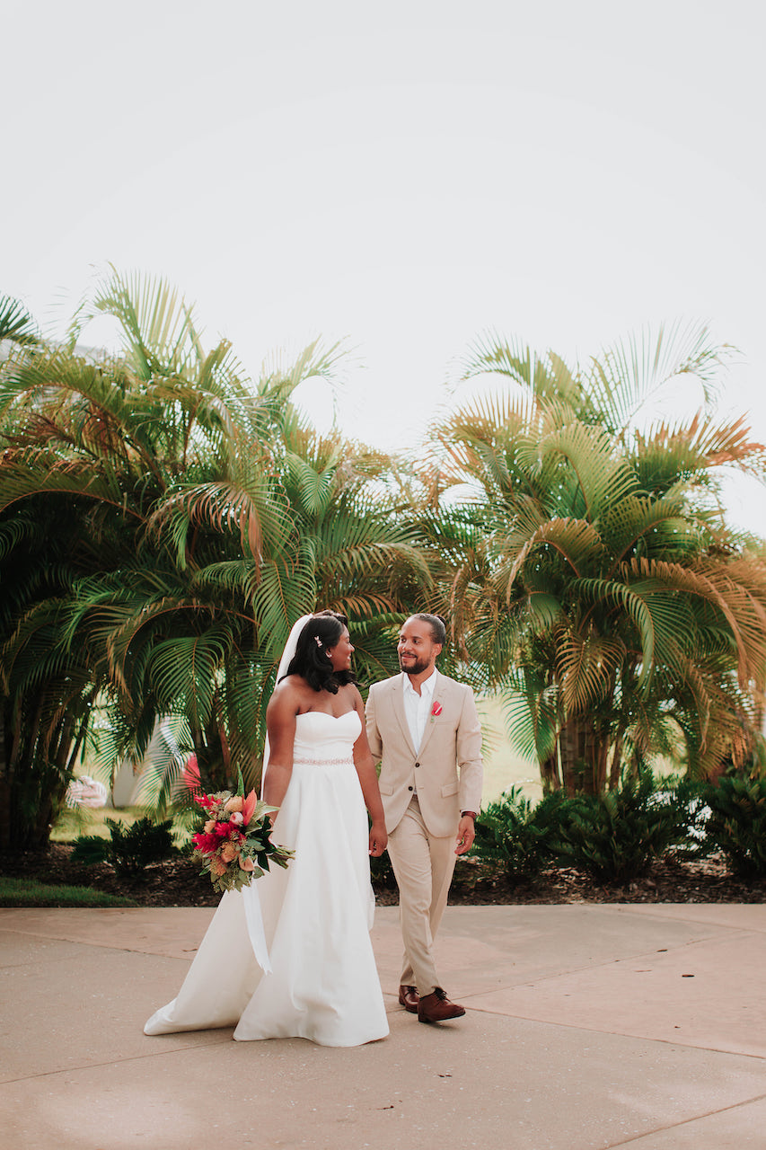 bride and groom in front of palm trees