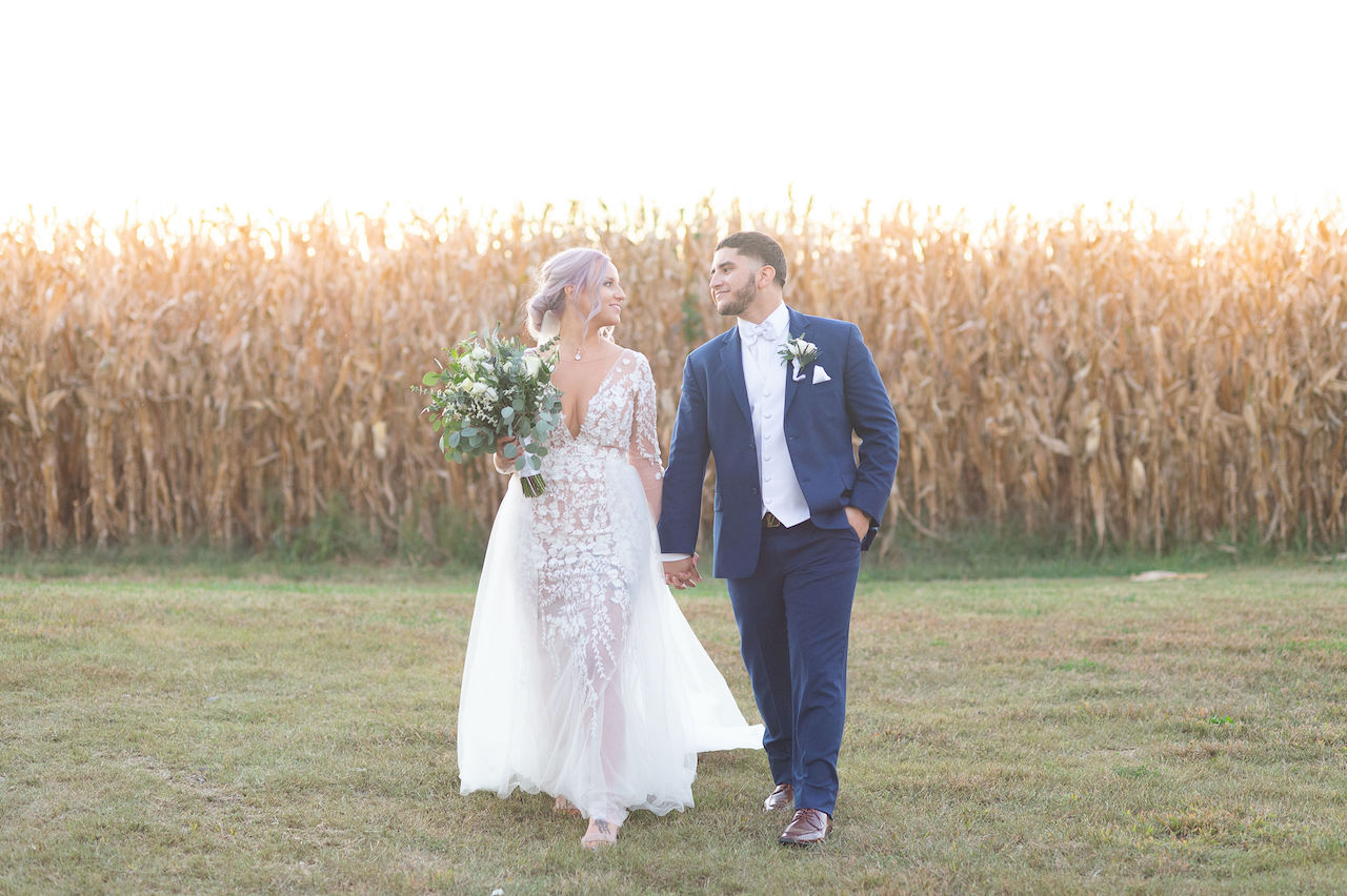 Bride and groom walking at rustic outdoor wedding in Delaware
