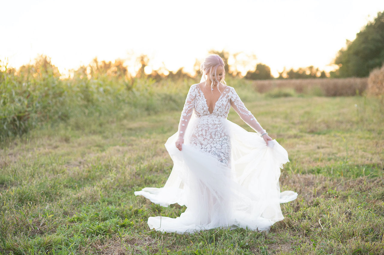bride twirling in lace sheer wedding gown at rustic outdoor wedding in Delaware
