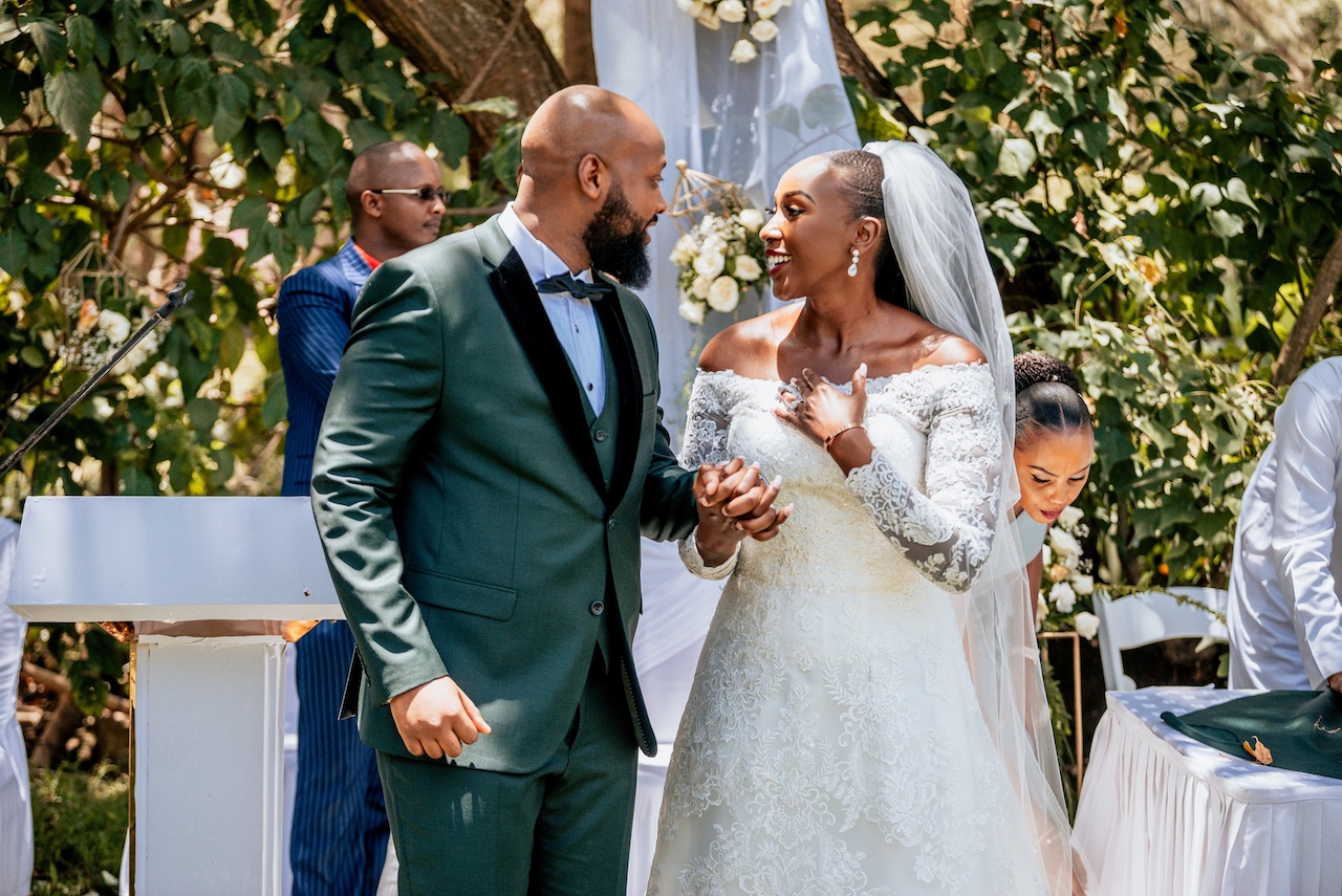 bride and groom holding hands at rustic wedding in kenya