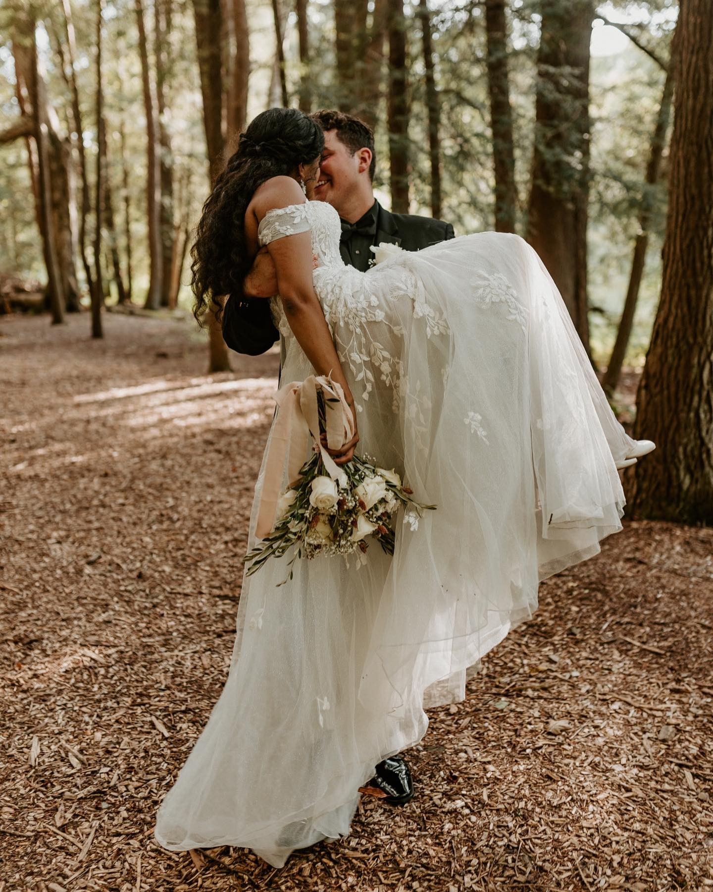 les mariés s'embrassent dans la forêt
