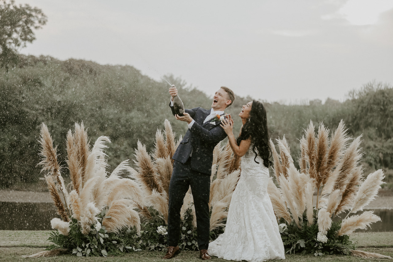 bride and groom popping champagne - ranch wedding in california
