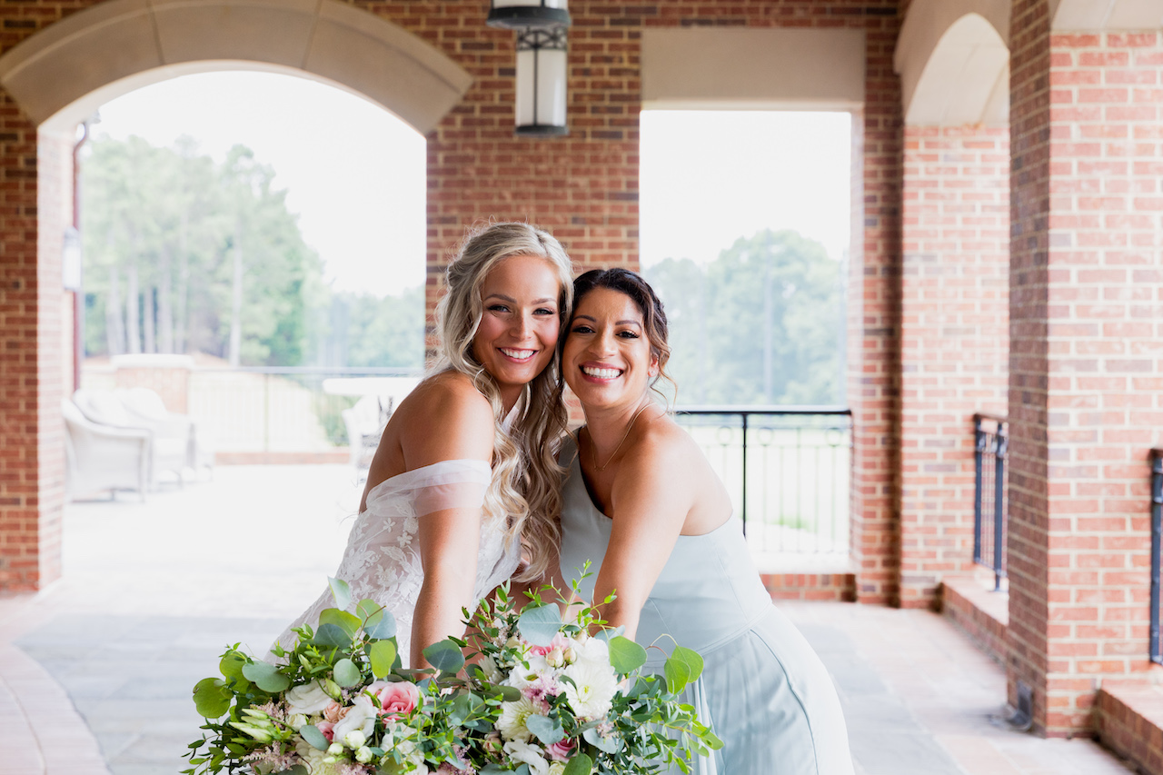 bride and bridesmaid smiling 
