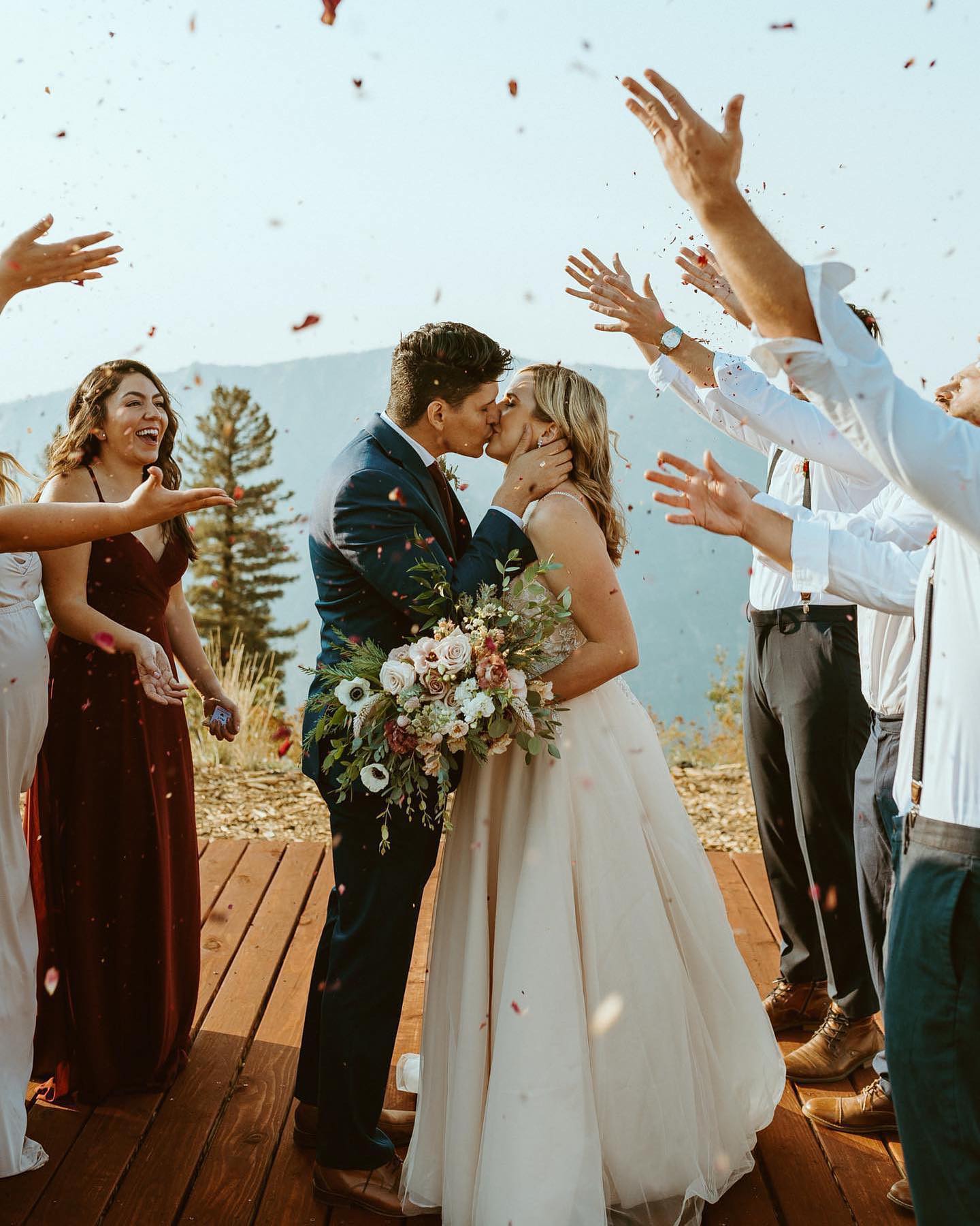 bride and groom kiss as confetti is thrown