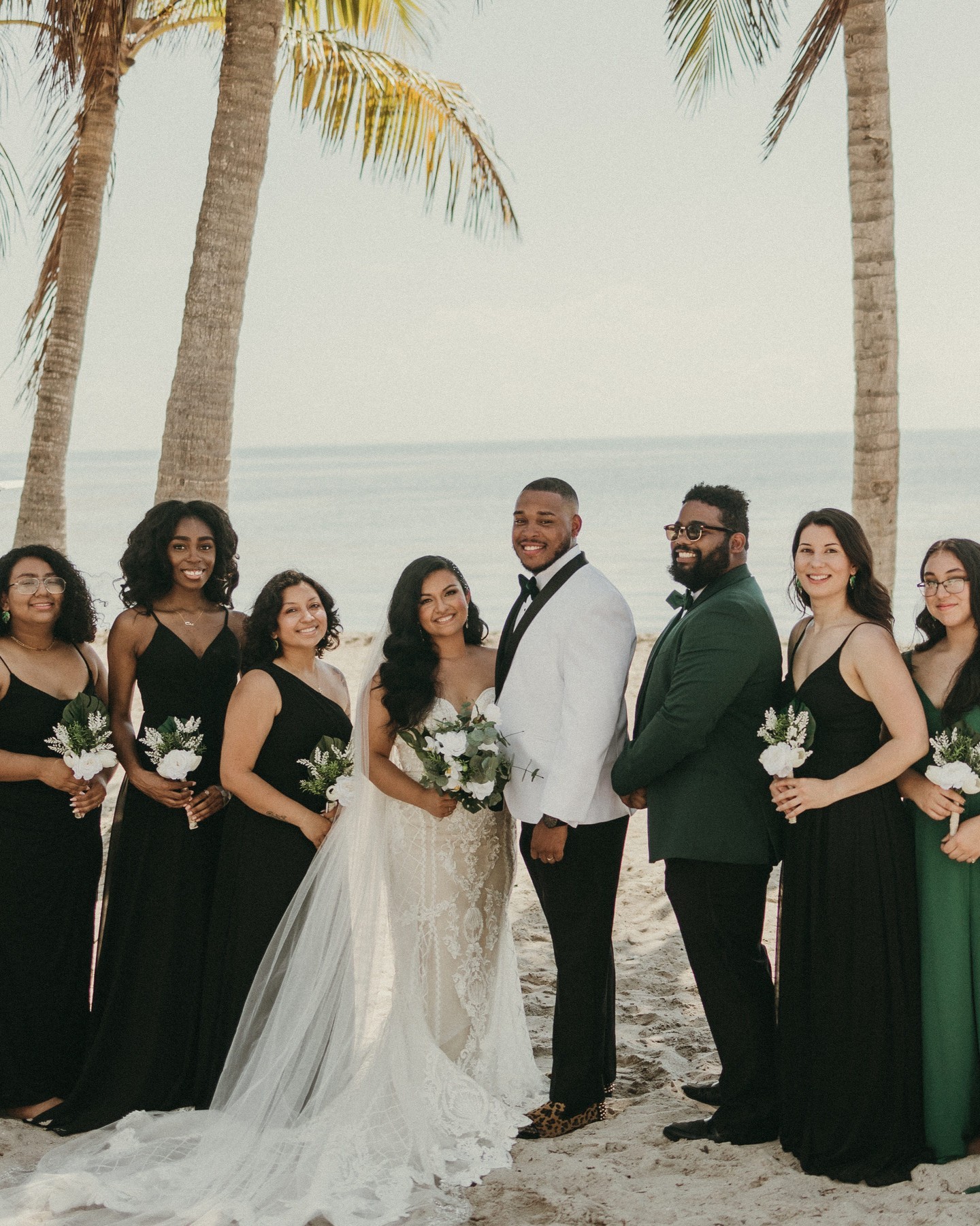 wedding party posing in front of tropical backdrop