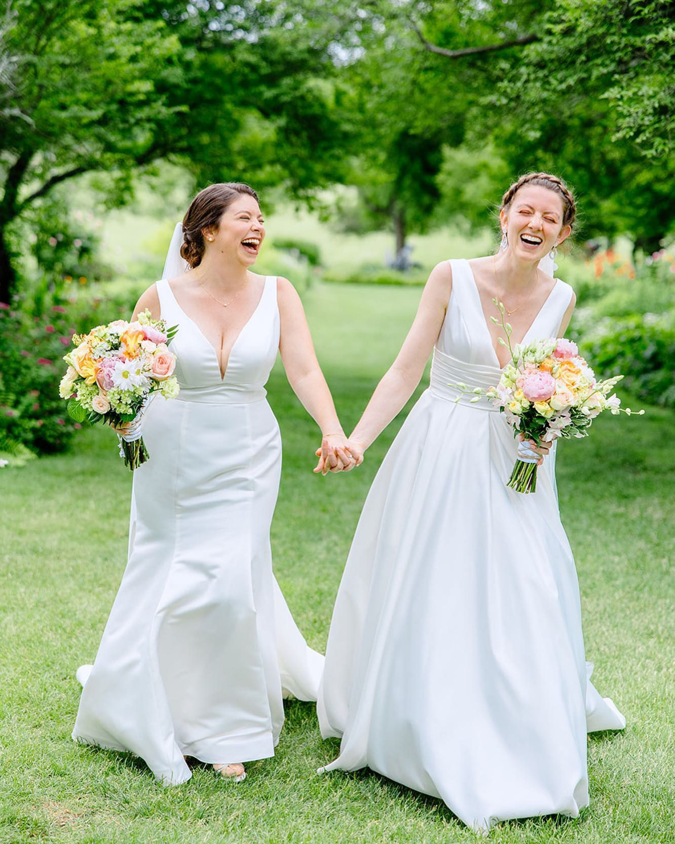 brides smiling and laughing while holding hands