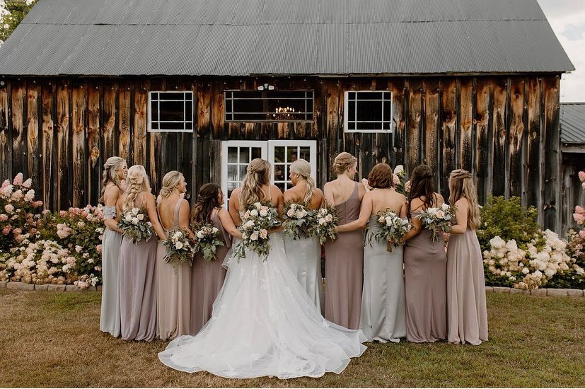 bride and bridesmaids in barn wedding venue